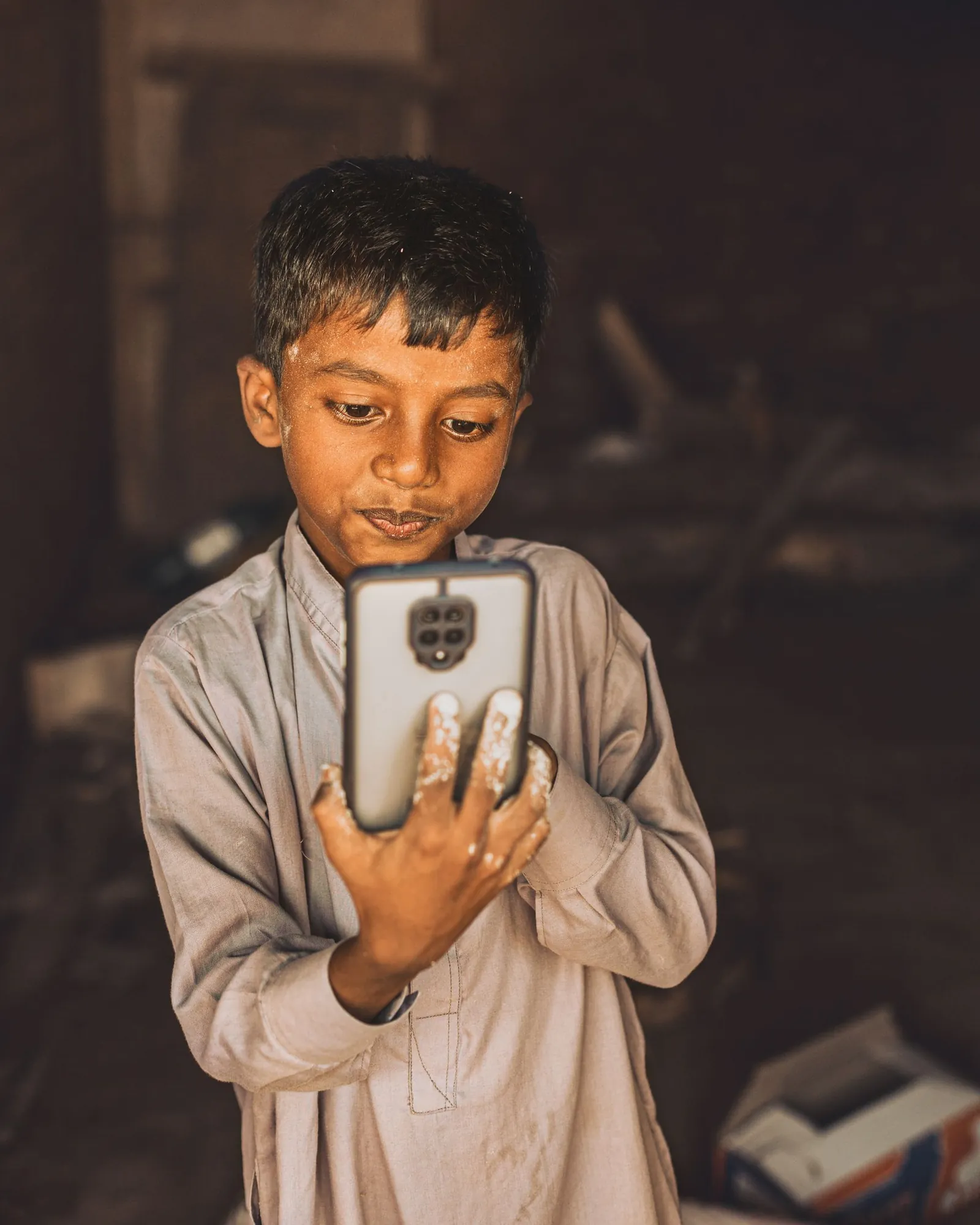 अंधेरे कमरे में एक लड़का, phone की रोशनी में उसका चेहरा
