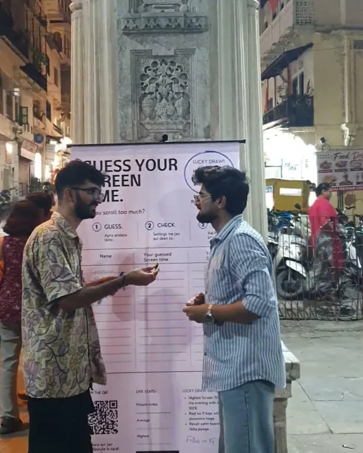 A young man in a striped shirt at the board at Gangaur Ghat, about to guess